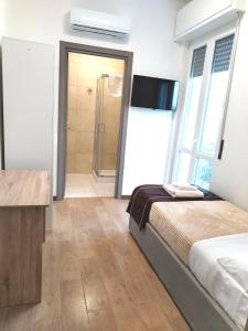 um quarto com uma cama e uma cabina de duche ao nível do chão em FIERA ROOMS em Verona