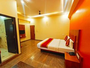 1 Schlafzimmer mit einem großen Bett und einem Badezimmer in der Unterkunft Hotel Champion Prince Yelahanka in Yelahanka