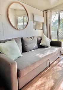 a couch in a living room with a mirror at Mornington Peninsula Retro Caravans in Rye