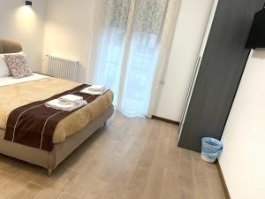 um quarto com uma cama e uma grande janela em FIERA ROOMS em Verona
