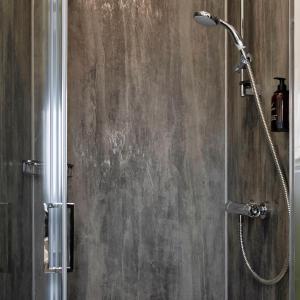 a shower with a shower head in a bathroom at Sandcliff Guest House in Cromer