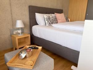 a bedroom with a bed and a wooden tray with a table at Paradies in den Südsteirischen Weinbergen: Bezauberndes Apartment mit Terrasse, Infinity Pool-Zugang, Sauna und Fitnessbereich! in Obegg