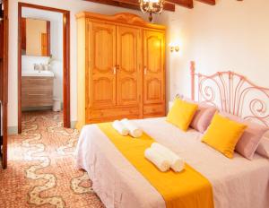 ベニッサにあるCasa Casanovaのベッドルーム1室(大型ベッド1台、黄色とピンクの枕付)