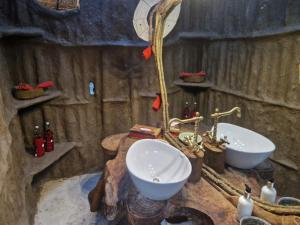 ein Badezimmer mit zwei Waschbecken in einer Holzwand in der Unterkunft Original Maasai Lodge – Africa Amini Life in Ngare Nanyuki