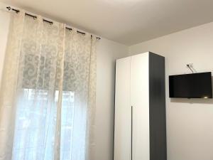 a living room with a cabinet and a window at FIERA ROOMS in Verona