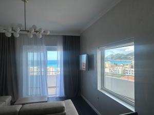 a living room with a couch and a large window at Apartmani Sunce in Bar