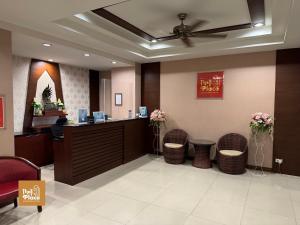 a hotel lobby with a reception desk and chairs at The1place in Khon Kaen