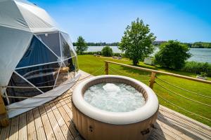a hot tub on a deck with a tent at Lake Glamp Mikołajki - Adults Only in Mikołajki