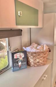 um livro e um cesto num balcão de cozinha em Mornington Peninsula Retro Caravans em Rye
