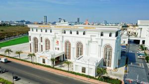 a white building with palm trees in front of a street at THE PREMIER PALACE HOTEL AND SPA in Phnom Penh