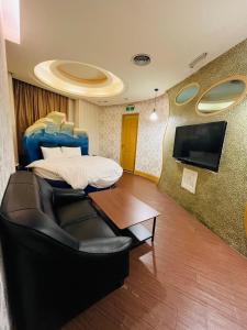 台北的住宿－沃客商旅 承德館，客房设有床、沙发和桌子。