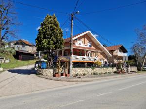 een huis aan de kant van een straat met een boom bij Stara Ruža in Gračanica