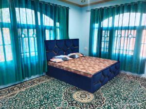 a bedroom with a bed with blue walls and windows at Moonlight Homestay Gulmarg in Srinagar
