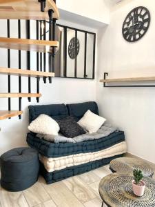 ein Wohnzimmer mit einem blauen Sofa und einer Uhr in der Unterkunft Villa Maya 5 - Aglandau - AVIGNON - CLIM - WIFI in Avignon