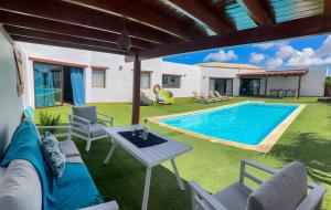 a backyard with a pool and a table and chairs at casa verde in Lajares
