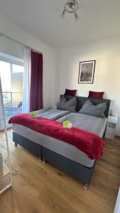 ein Schlafzimmer mit einem großen Bett mit einer roten Decke in der Unterkunft CityLake G23 Apartments mit kostenlosem Parkgaragen-Stellplatz !! in Gmunden