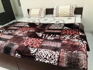 a bed with a cheetah quilt on it at Ramaya Home Stay in Varanasi