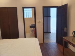 um quarto com uma cama e 2 portas para uma casa de banho em Hotel ĐUC THANH VINH em Củ Chi