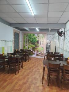 uma sala de jantar com mesas e cadeiras de madeira em Hotel ĐUC THANH VINH em Củ Chi