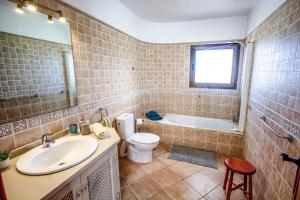 a bathroom with a sink and a toilet and a tub at casa verde in Lajares +5 photos