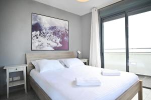 um quarto com uma cama grande com duas toalhas em City View 2BR Duplex with MAMAD by HolyGuest em Tel Aviv
