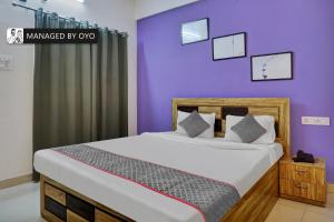 sypialnia z dużym łóżkiem i fioletowymi ścianami w obiekcie Townhouse Imperial Inn Hinjewadi w mieście Hinjewadi