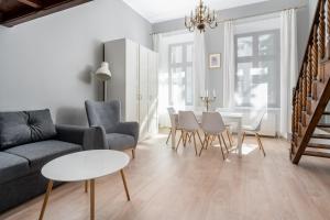 - un salon avec un canapé, des chaises et une table dans l'établissement Starowiślna 37 Apartment with Mezzanine, à Cracovie