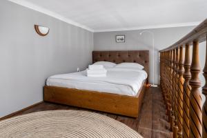 - une chambre avec un grand lit et une tête de lit en bois dans l'établissement Starowiślna 37 Apartment with Mezzanine, à Cracovie