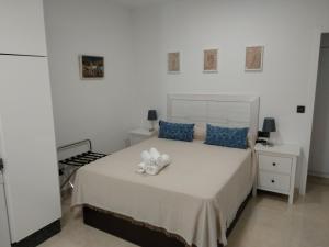 a bedroom with a white bed with blue pillows at Apartamentos Cordoba in Córdoba