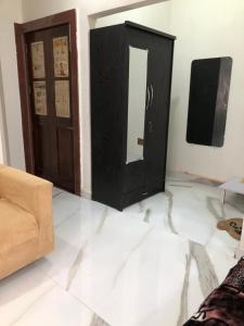 a living room with a black cabinet and a mirror at Ramaya Home Stay in Varanasi