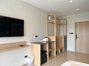 a room with a bed and a tv on a wall at The Way Hotel Ban Pong in Ban Pak Raet