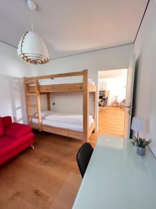 Pokój z łóżkiem piętrowym i czerwoną kanapą w obiekcie Ferienwohnung Angerer w mieście Bad Mitterndorf