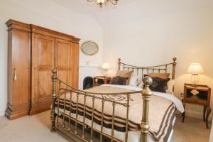 una camera con letto e armadio in legno di The Coach House a Haywards Heath