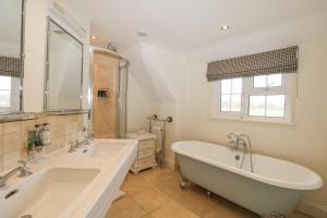 un bagno con due lavandini e una grande vasca di The Coach House a Haywards Heath