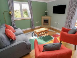 a living room with a couch and chairs and a television at The Annexe, Meadow Croft in Haverfordwest