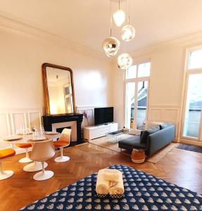 ein Wohnzimmer mit einem blauen Sofa und einem Spiegel in der Unterkunft Le Carré Bleu - Studio Confort - Centre-ville in Dieppe