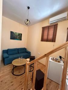 Sofias Home في مدينة خانيا: غرفة معيشة مع أريكة زرقاء وطاولة