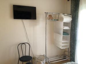 Pokój z krzesłem i telewizorem z płaskim ekranem w obiekcie Noailles w mieście Le Bouscat