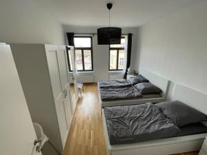 Habitación con 2 camas y pasillo con ventanas. en #attraktive zentrumnahe Wohnung am Hauptbahnhof 2OG rechts en Leipzig