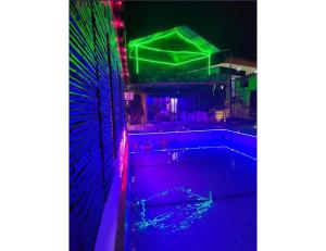 una piscina con luces de colores en el lateral de un edificio en Limewood Resort & Restaurant, Kushinagar, en Kushinagar