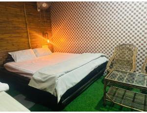 1 dormitorio pequeño con 1 cama y 1 silla en Limewood Resort & Restaurant, Kushinagar, en Kushinagar