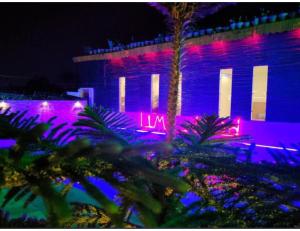 un edificio iluminado con luces moradas y azules en Limewood Resort & Restaurant, Kushinagar, en Kushinagar