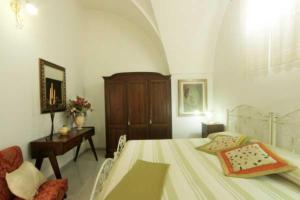 - une chambre avec un lit, une commode et une table dans l'établissement Corte Antica 3, à Presicce