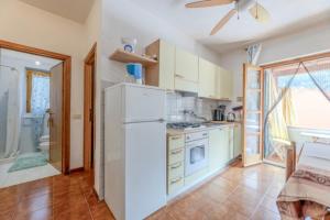 a kitchen with a white refrigerator and a sink at La Margherita alla Zanca - Goelba in Zanca +10 photos
