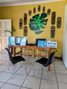 een tafel en twee stoelen voor een gele muur bij Screaming Gecko Hostel Air-Con in Busuanga