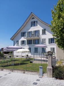 Gasthaus zum Bauernhof في Oberlunkhofen: مبنى ابيض كبير فيه مظلات امامه
