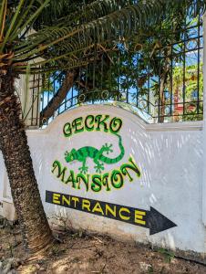 un segno per un ingresso di Marcart con un dinosauro sopra. di Screaming Gecko Hostel Air-Con a Busuanga