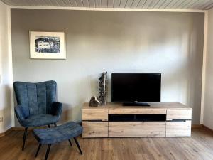 salon z telewizorem i krzesłem w obiekcie Urlaub im Sonnendorf Burgberg w mieście Burgberg