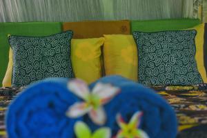 a bed with colorful pillows and a bed with flowers at Ume Sita Villa and Homestay in Ubud