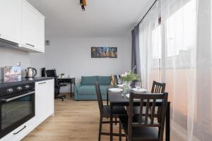 a kitchen and living room with a table and chairs at Luxury Apartment with Balcony & Parking Cracow by Renters Prestige in Krakow